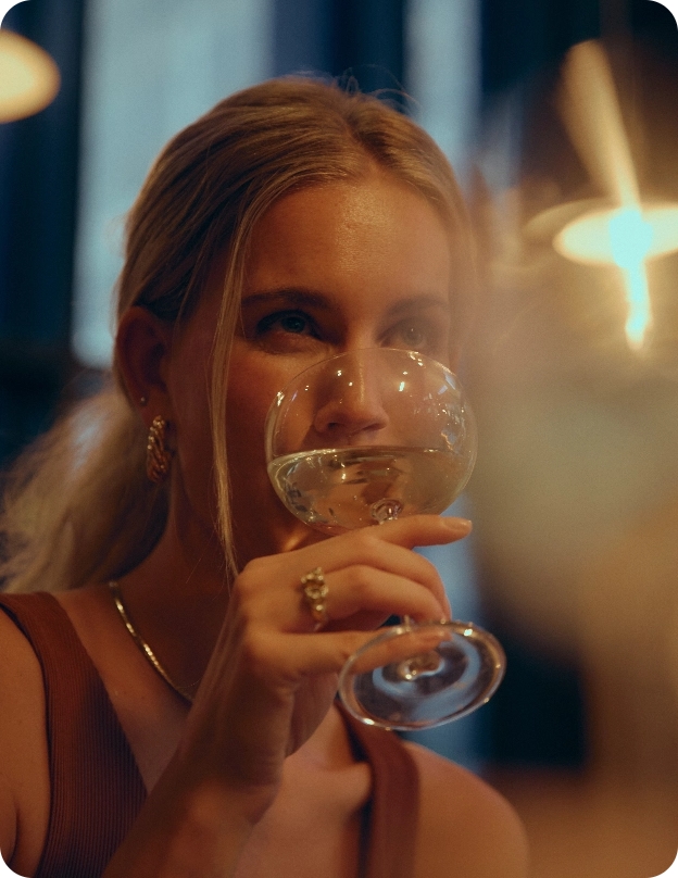 Woman drinking wine at night